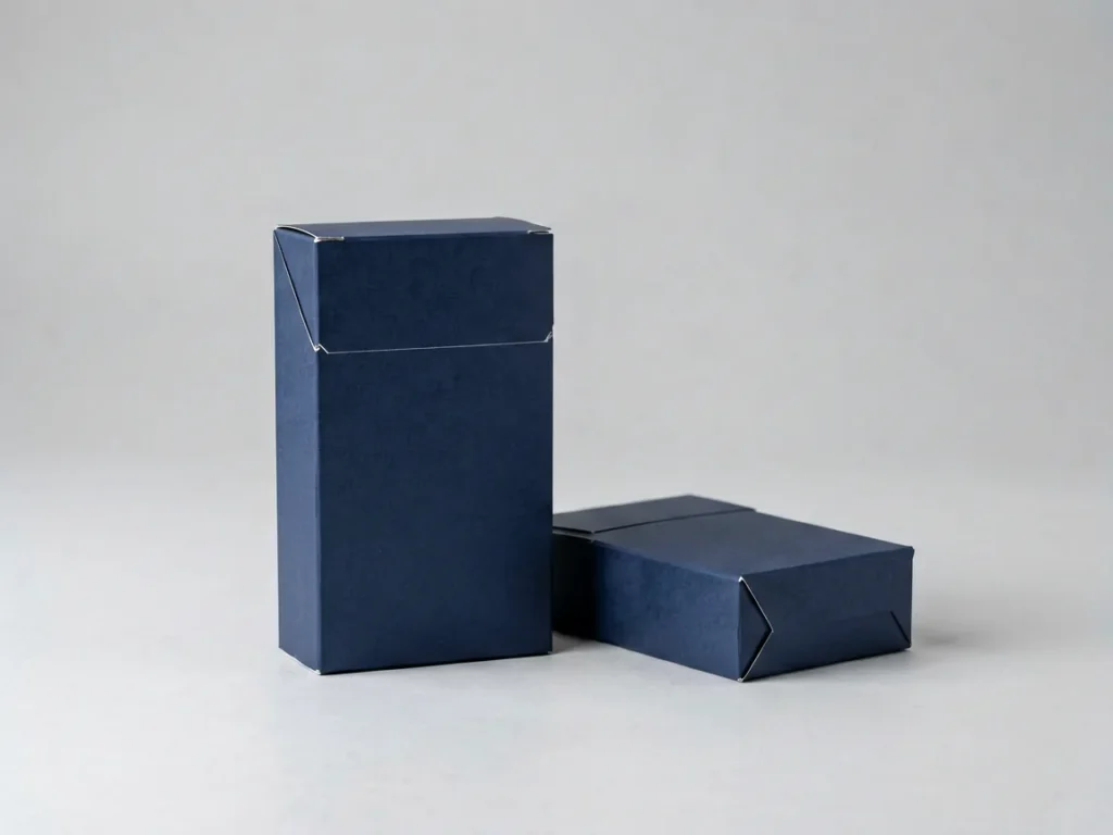 Plain cardboard cigarette carton and closed pack with no logos, illustrating the Vietnamese Kent Switch catalogue record in the Virqalo adult catalogue. Adults 18+ only.