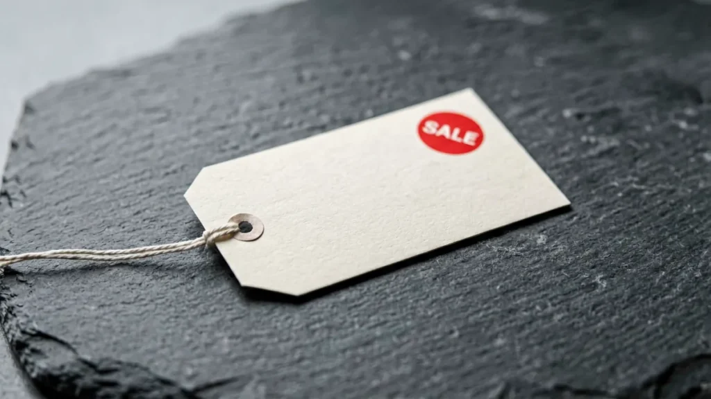 Sale price tag with a red sale sticker next to a plain catalogue record card, illustrating the regular price and current price fields on a Virqalo product page. Australian adults 18+ only.